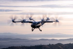 An electric aircraft flying over mountains.